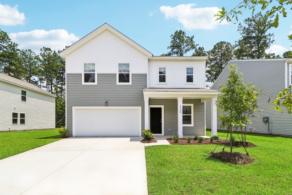 Sycamolre white and gray house with a lawn and a driveway at Beacon at Ashley River Landing in Summerville, SC