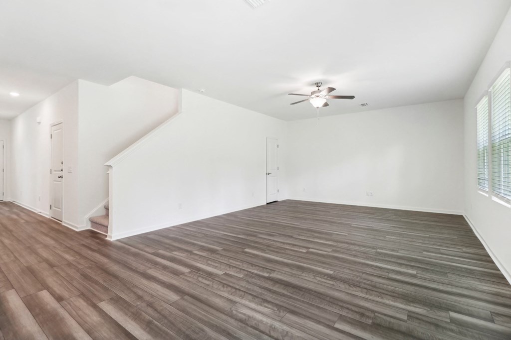 Sycamore living room with white walls connected to the stairs at Beacon at Ashley River Landing in Summerville, SC