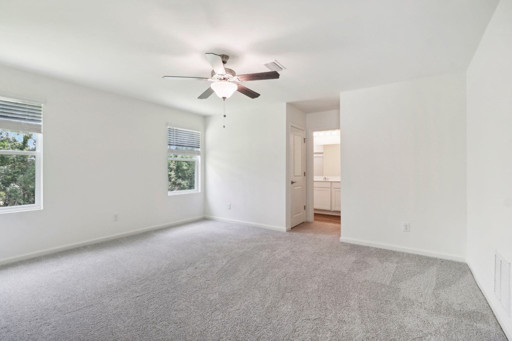 Sycamore master bedroom with ceiling fan and carpet flooring at Beacon at Ashley River Landing in Summerville, SC