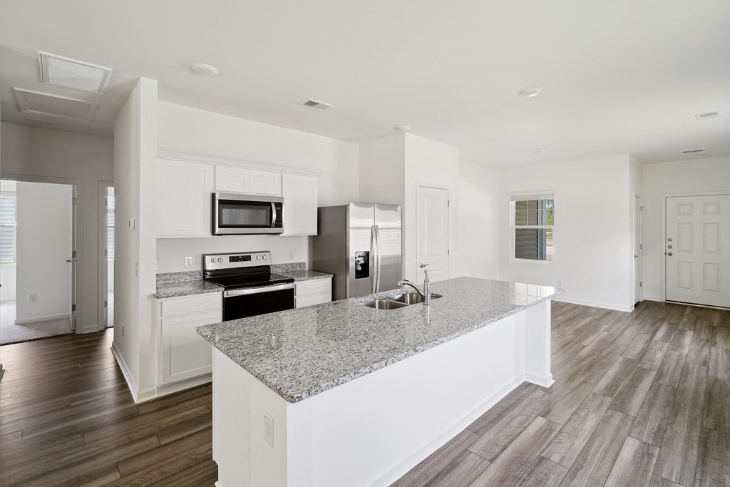 a kitchen with white cabinets and a granite counter top at Beacon at Meridian, Texas, 78245