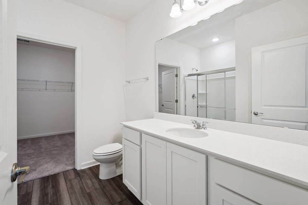 a bathroom with a toilet sink and mirror at Beacon at Meridian, Texas