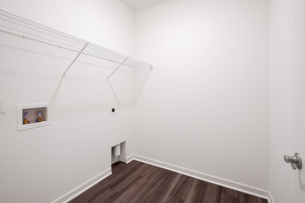 a walkin closet with white walls and a wooden floor at Beacon at Meridian, Texas