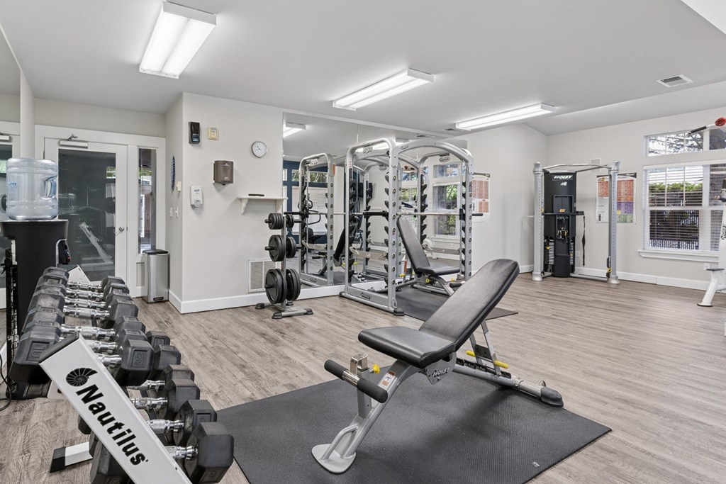 A gym with weights and strength training machines at Abbey Rowe Apartments in Olympia, WA