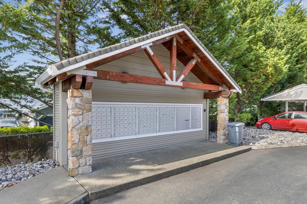 A covered mailbox area with a wooden roof at Abbey Rowe Apartments in Olympia, WA