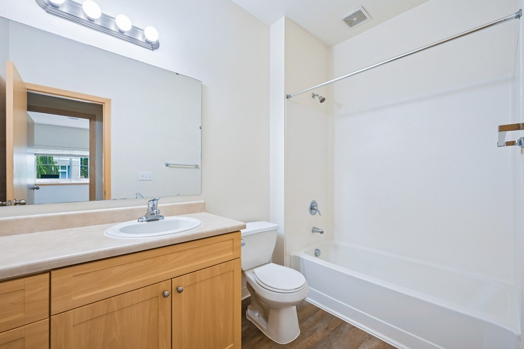 Soho bathroom with a vanity sink, toilet, and bathtub at Abbey Rowe Apartments in Olympia, WA