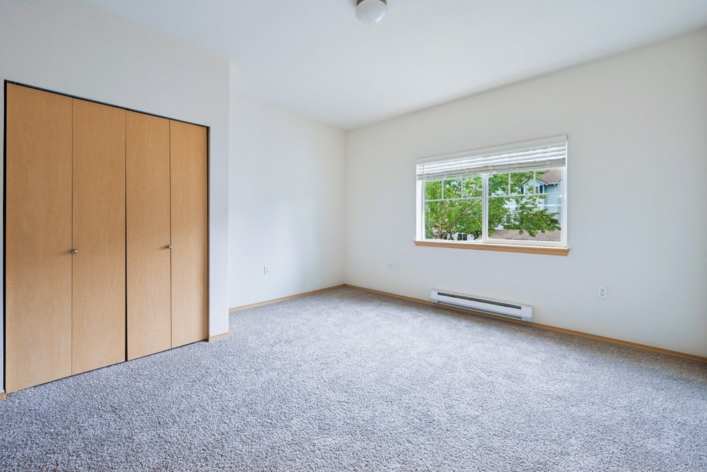 Soho bedroom with a window and a carpeted floor at Abbey Rowe Apartments in Olympia, WA