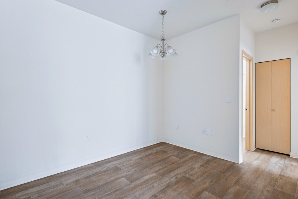 Soho dining room with a wooden floor and a ceiling light at Abbey Rowe Apartments in Olympia, WA