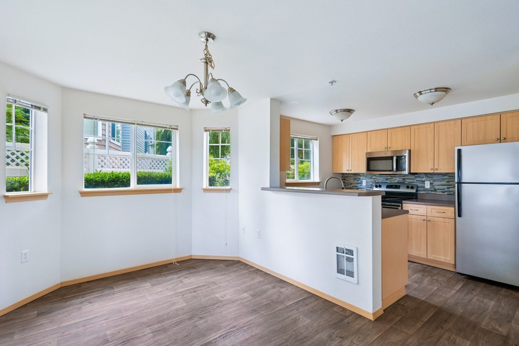 York dining room and kitchen with four windows and wood cabinets at Abbey Rowe Apartments in Olympia, WA