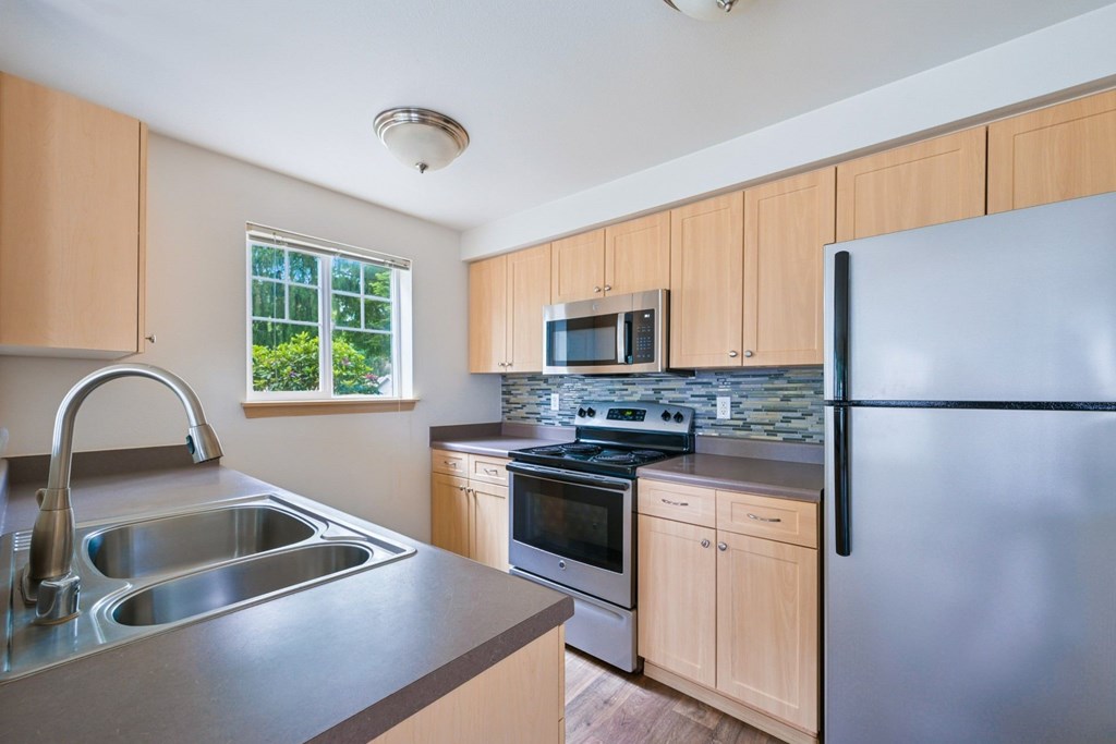 York kitchen with stainless steel appliances and a window at Abbey Rowe Apartments in Olympia, WA