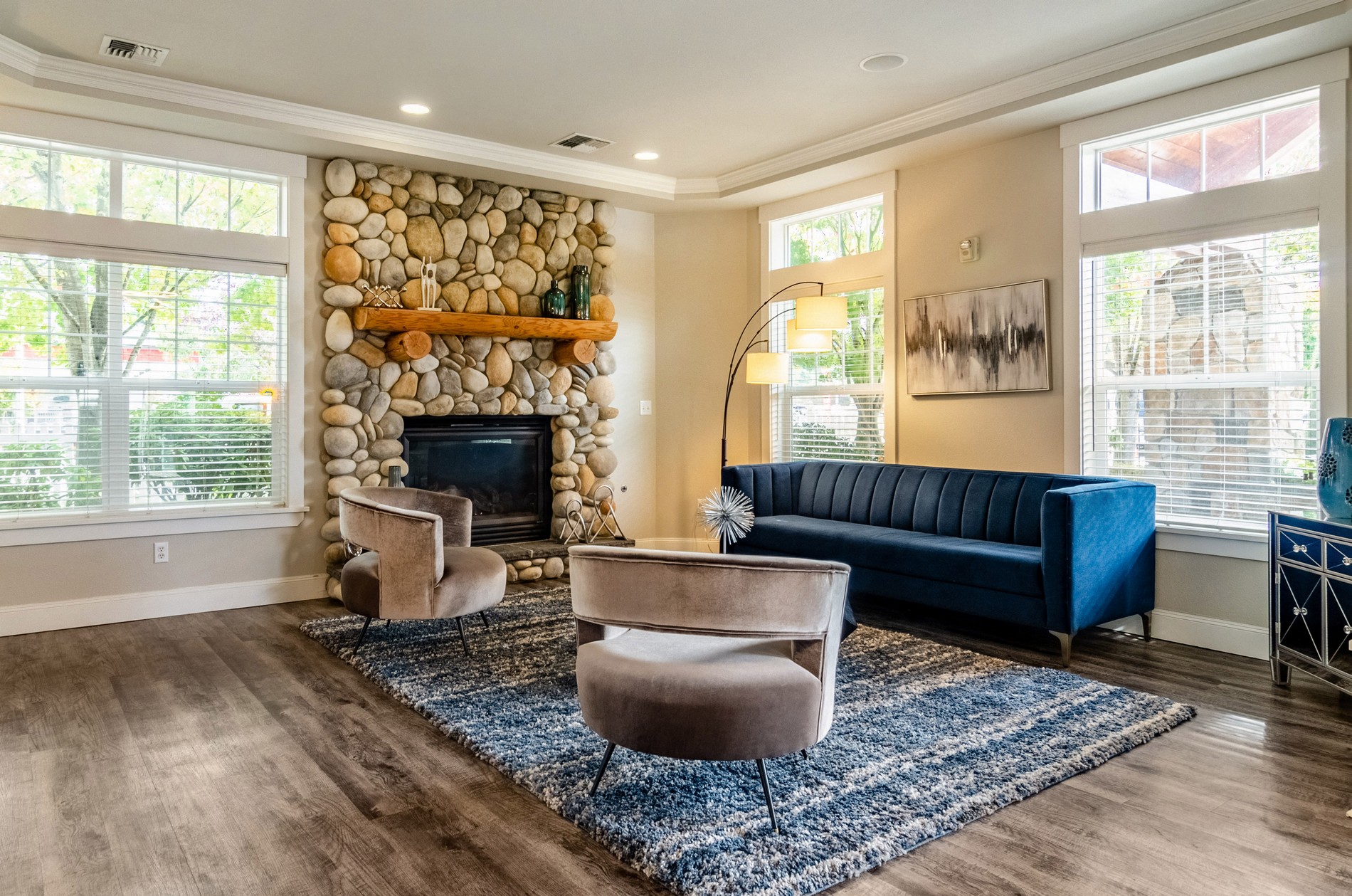 a living room with a stone fireplace and a blue couch