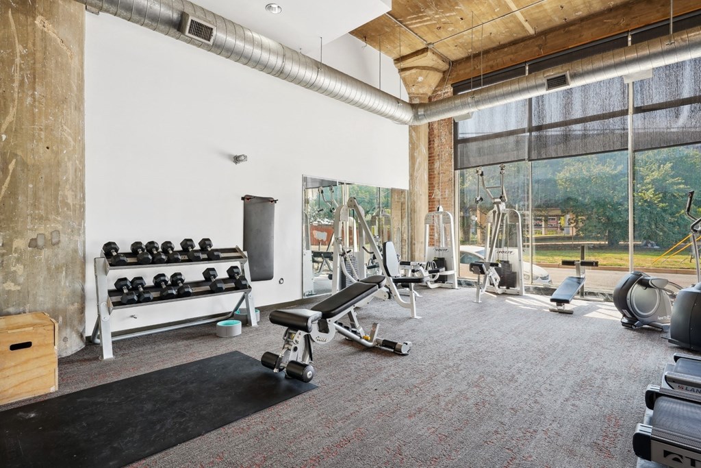 Adam Hats fitness center with free weights and cable weight equipment with large windows | Adam Hats Lofts from Deep Ellum Lofts in Dallas, TX