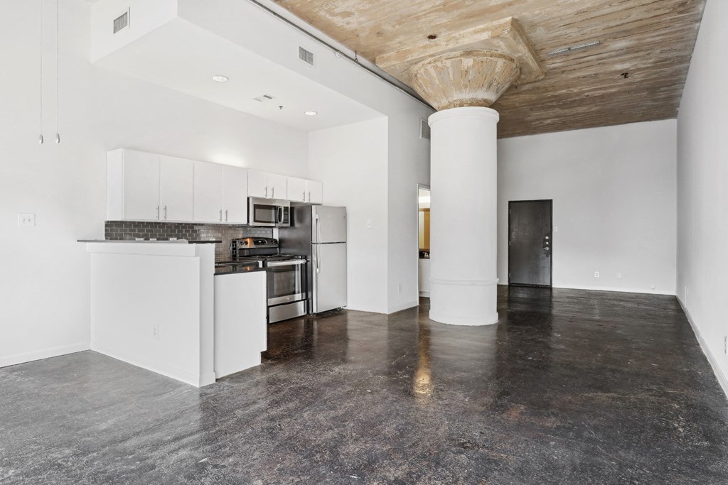 Loft kitchen and living area with polished concrete floors | Adam Hats Lofts from Deep Ellum Lofts in Dallas, TX
