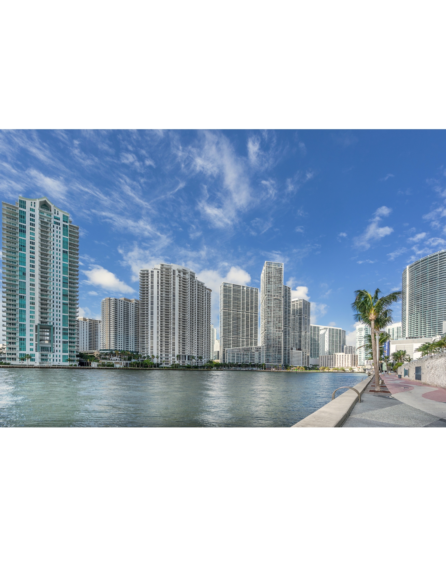 A row of modern buildings line a waterfront.