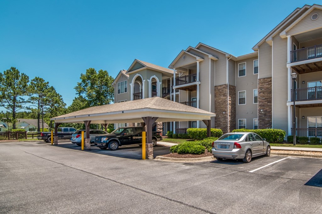 a parking lot with cars parked in front of an apartment building