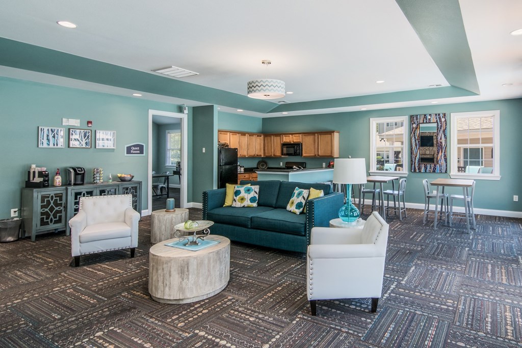 a living room with blue walls and furniture and a kitchen
