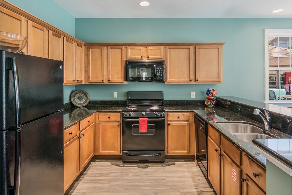 a kitchen with black appliances and wooden cabinets