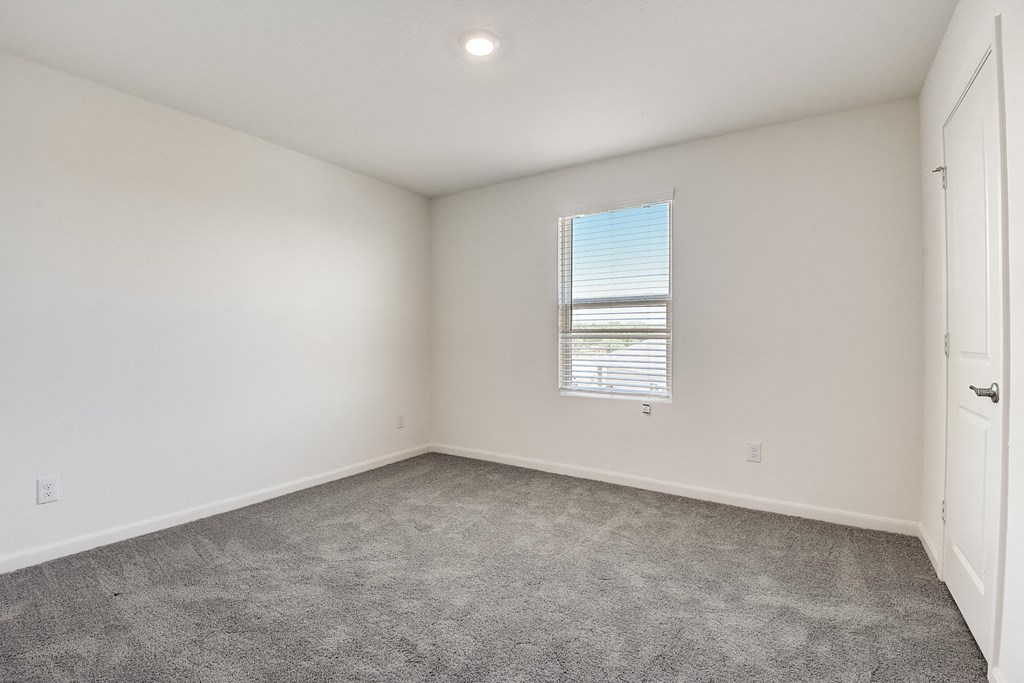 a bedroom with white walls and carpet at Beacon at Meridian, San Antonio