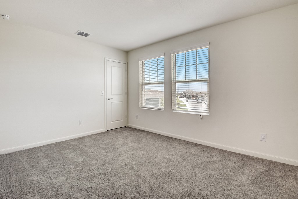 a bedroom with a door and two windows at Beacon at Meridian, San Antonio, TX