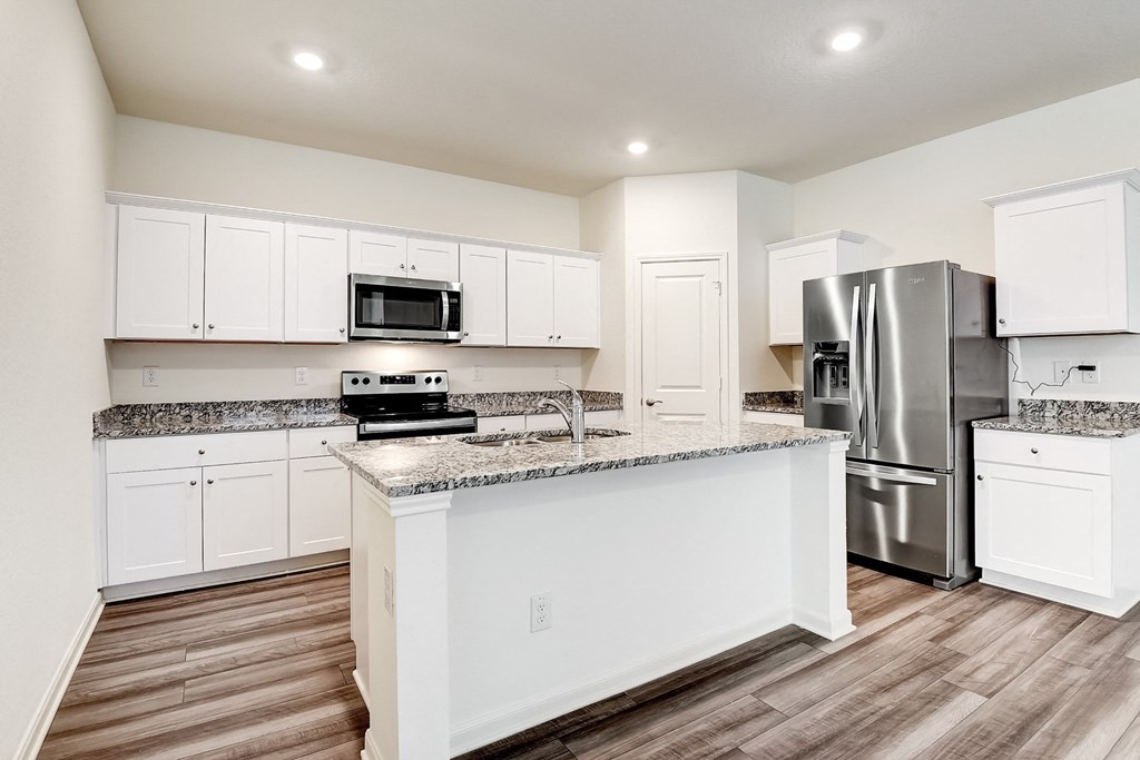 a kitchen with an island and stainless steel appliances at Beacon at Meridian, San Antonio Texas
