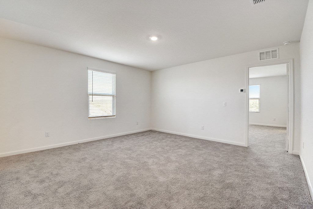 a bedroom with white walls and carpet