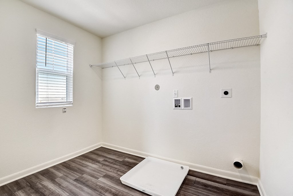 a closet with white walls and a window
