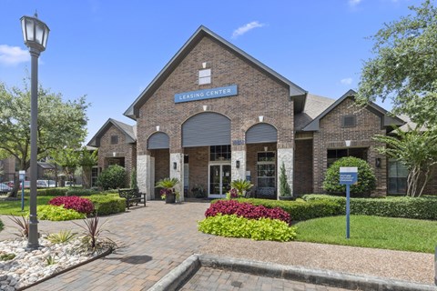 Leasing office front surrounded by a well-manicured garden at Asheville at Spring Branch apartments in Houston, TX
