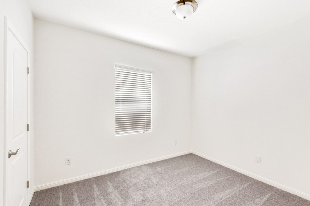 a bedroom with white walls and carpet