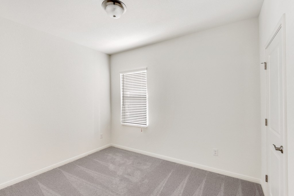 a bedroom with white walls and carpet at Beacon at Meridian, San Antonio