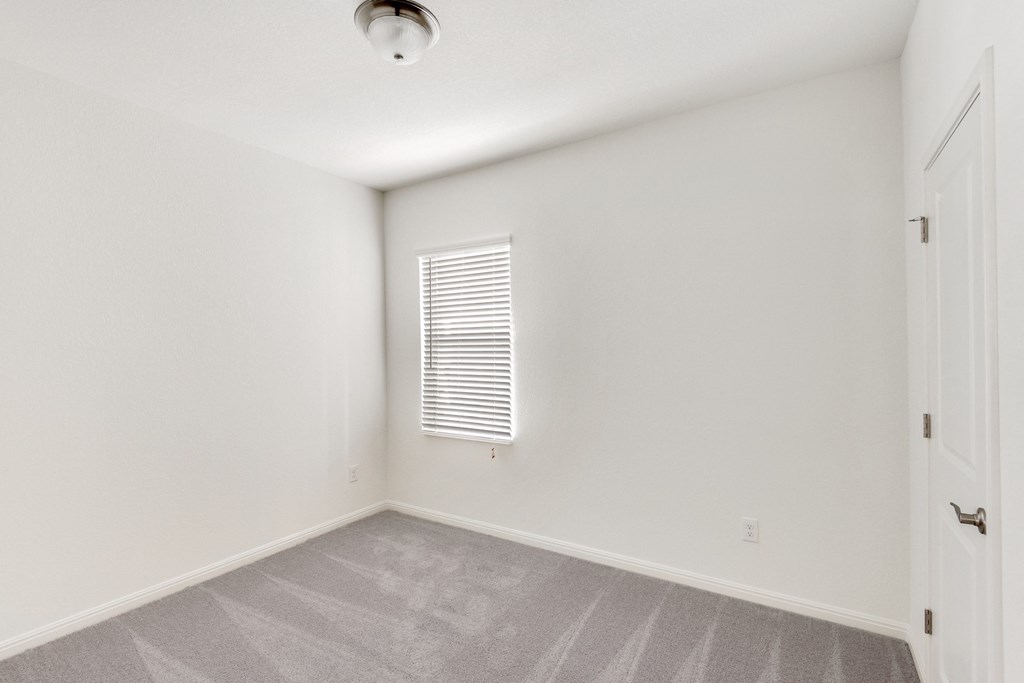 a bedroom with white walls and carpet