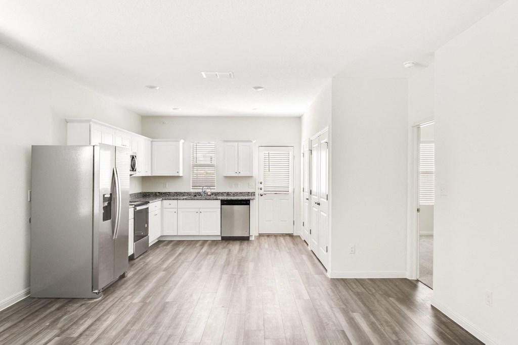 a kitchen with white cabinets and stainless steel appliances