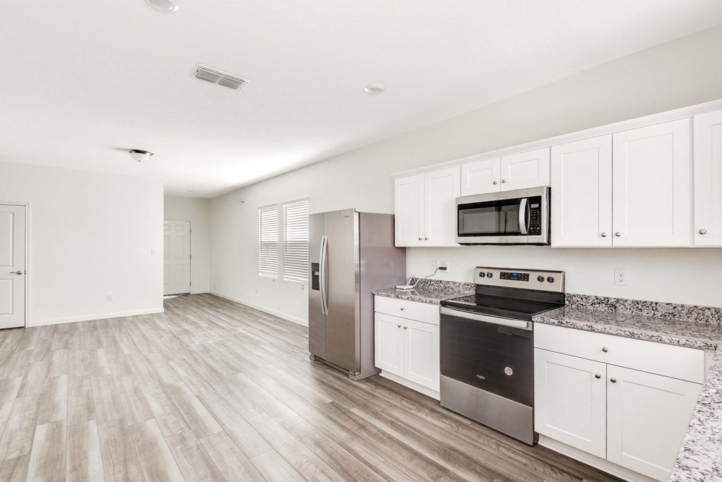 a kitchen with white cabinets and stainless steel appliances