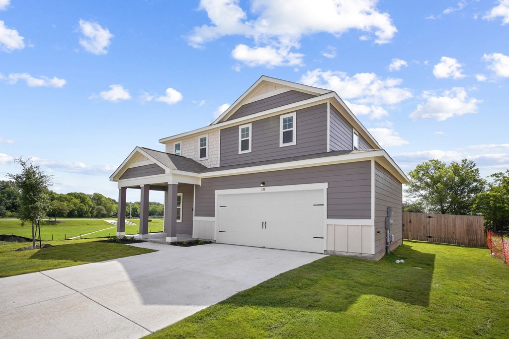 a home with a gray siding and a white garage door at Beacon at Bunton Creek, Kyle, TX 78640