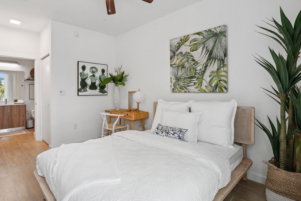 a bedroom with white walls and a white bed with white bedding