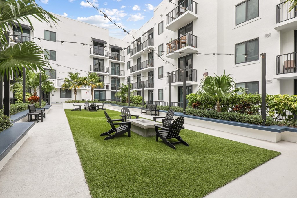 a courtyard with a table and chairs in front of some apartments