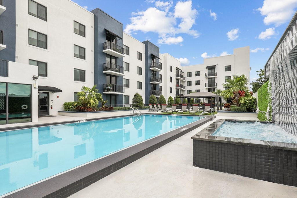 a swimming pool with an apartment building in the background