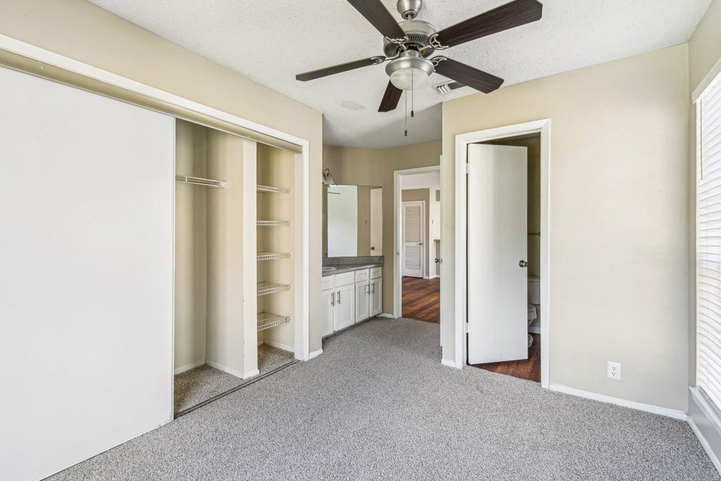 Modern bedroom with carpet and ceiling fan at Bandera Crossing apartments in San Antonio, TX
