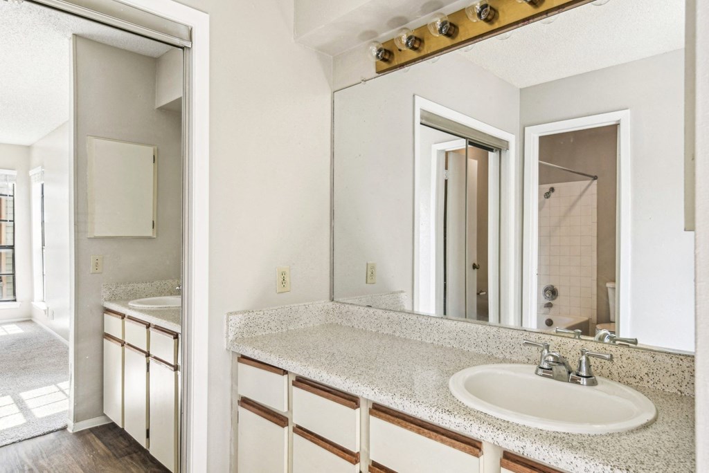 Spacious bathroom with a big sliding mirror on the left side at Bandera Crossing apartments in San Antonio, TX