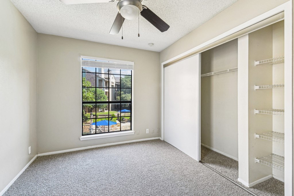 Bright bedroom with a big window at Bandera Crossing apartments in San Antonio, TX