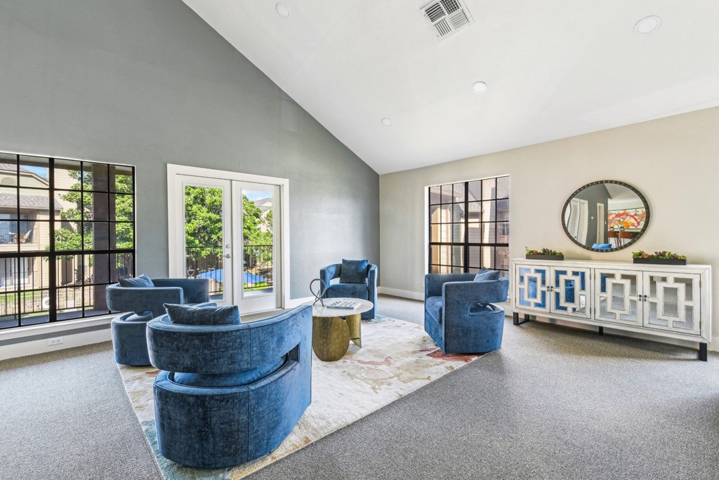 Plush blue single seat couches in two-story clubhouse at Bandera Crossing apartments in San Antonio, TX