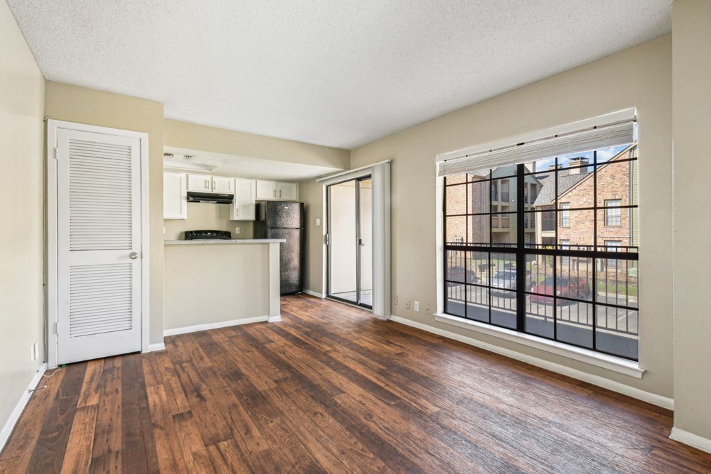 Spacious living room with large windows at Bandera Crossing apartments in San Antonio, TX