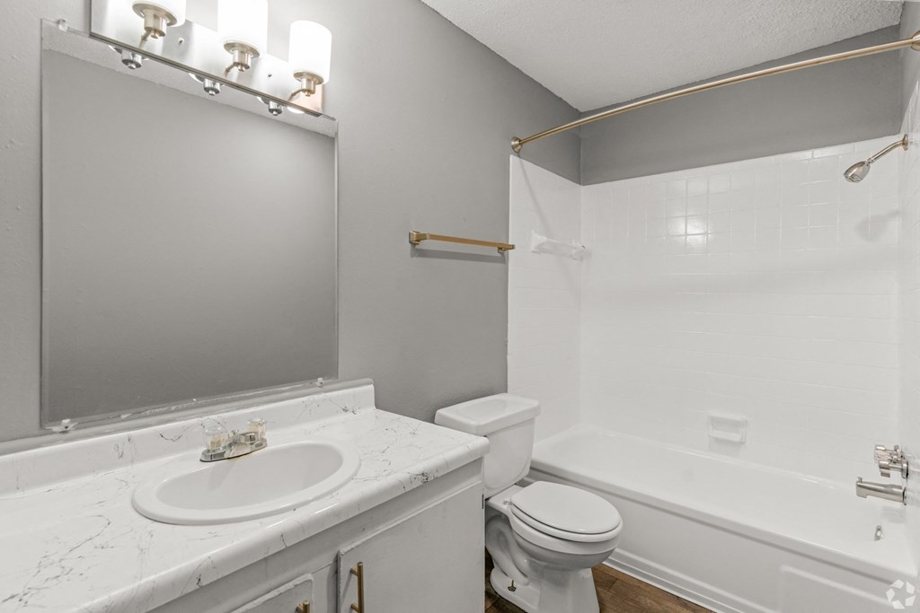 Apartment bathroom with a sink toilet and a tub at Bayou Oaks Apartment Homes in Alexandria, LA