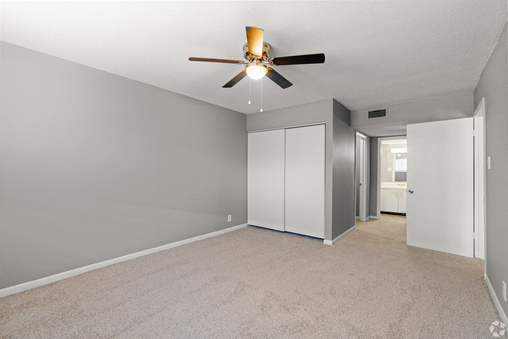 Apartment bedroom with ceiling fan and closet at Bayou Oaks Apartment Homes in Alexandria, LA