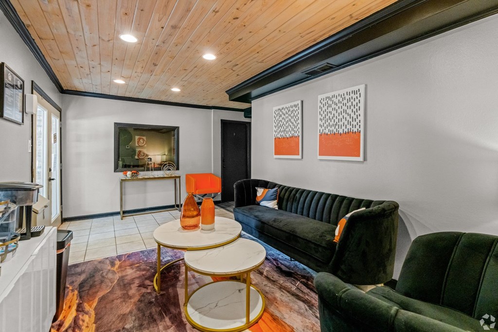Leasing office interior waiting and lounge space with couches and coffee table at Bayou Oaks Apartment Homes in Alexandria, LA