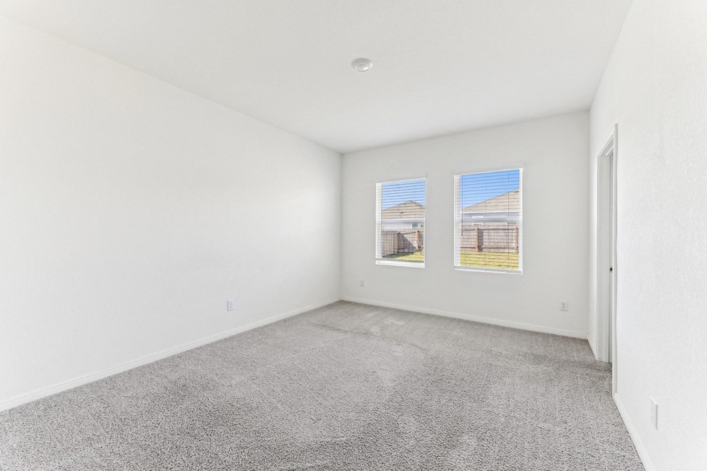 Spacious bedroom with ample natural light of Dogwood floor plan at Beacon at Presidential Heights in Manor, TX