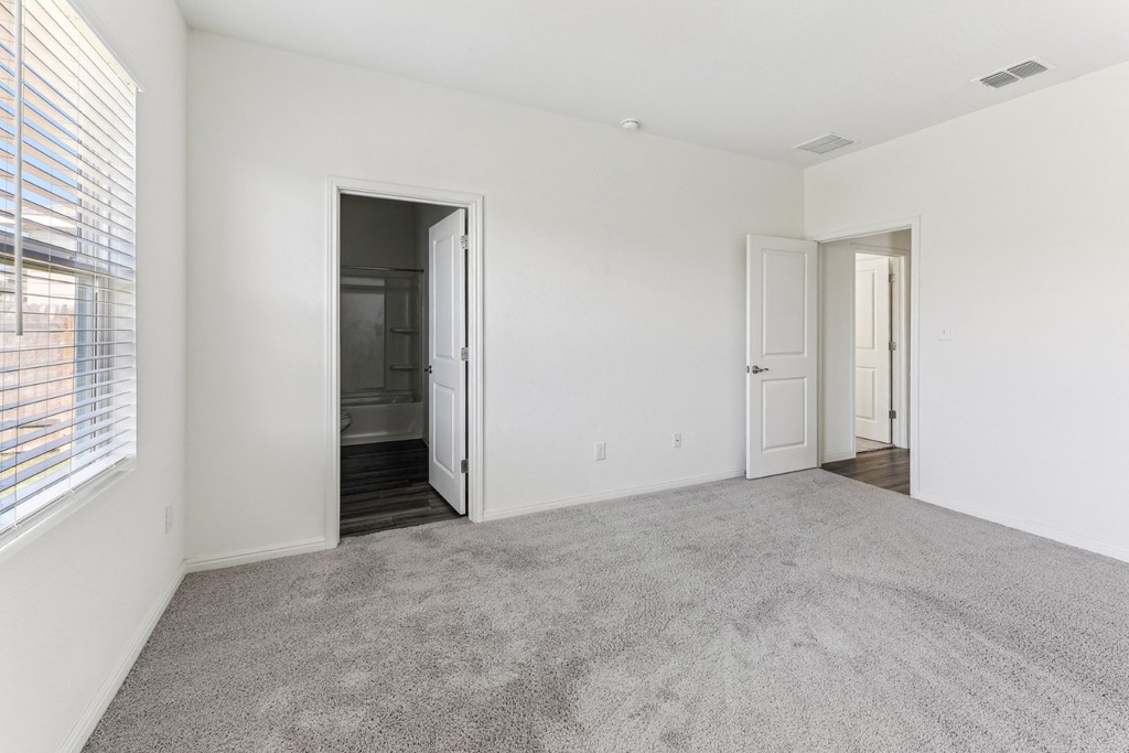 Cozy bedroom with plush carpeting of Dogwood floor plan at Beacon at Presidential Heights in Manor, TX