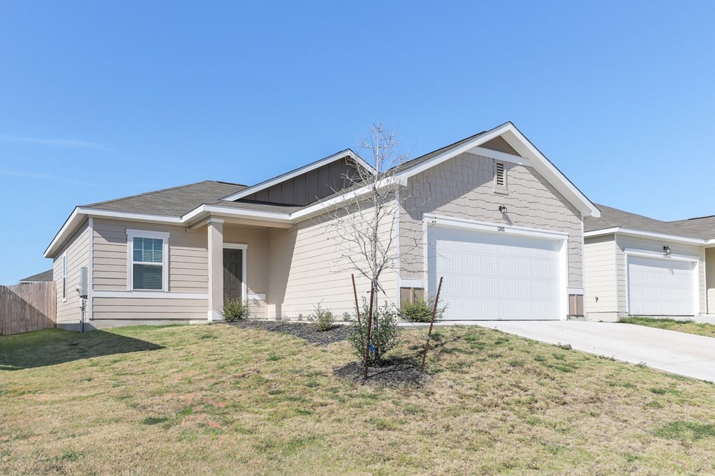 Side view of Dogwood one-story single-family rental house with a fenced-in yard at Beacon at Presidential Heights in Manor, TX