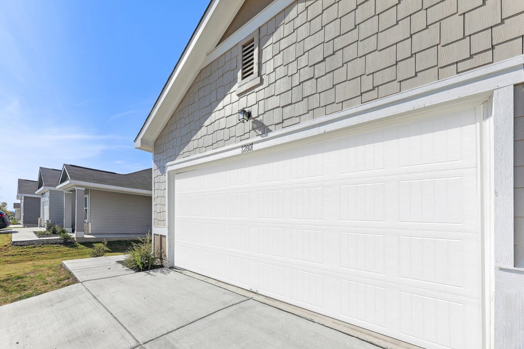 Attached garage of Dogwood home with ample parking space at Beacon at Presidential Heights in Manor, TX