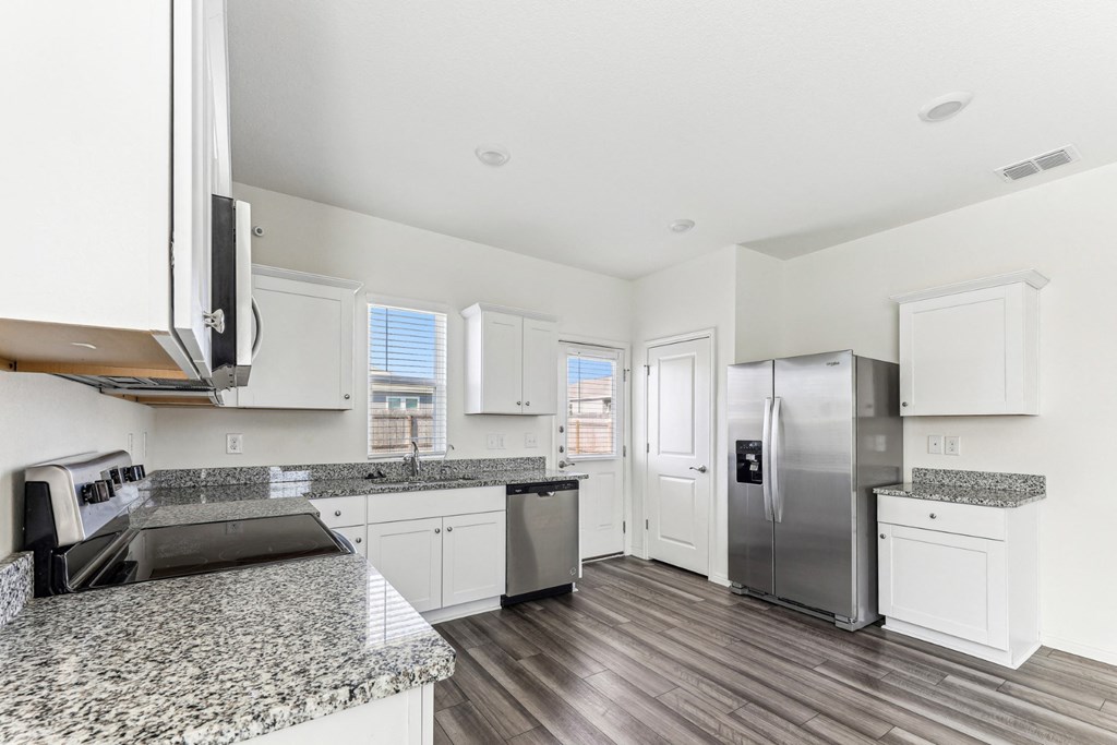 Modern kitchen at Dogwood home with stainless steel appliances at Beacon at Presidential Heights in Manor, TX