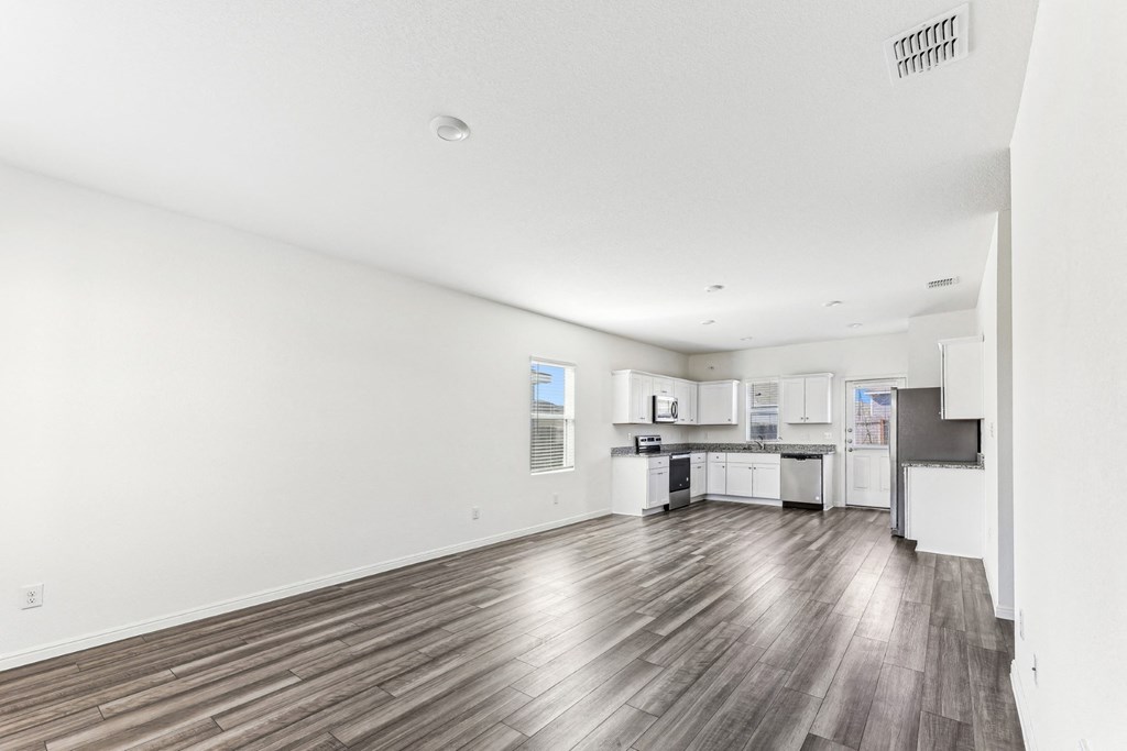 Modern living room with large windows and luxury vinyl floors of Dogwood floor plan at Beacon at Presidential Heights in Manor, TX