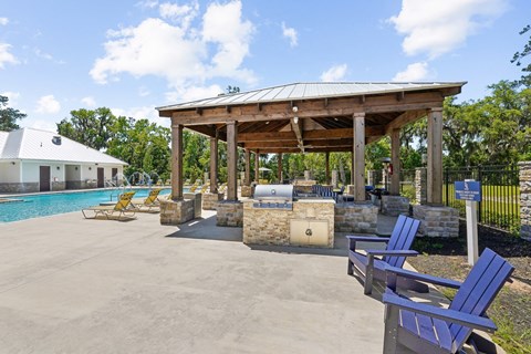 Grilling station at the pool area with seating at Capital Grand Apartments in Tallahassee, FL